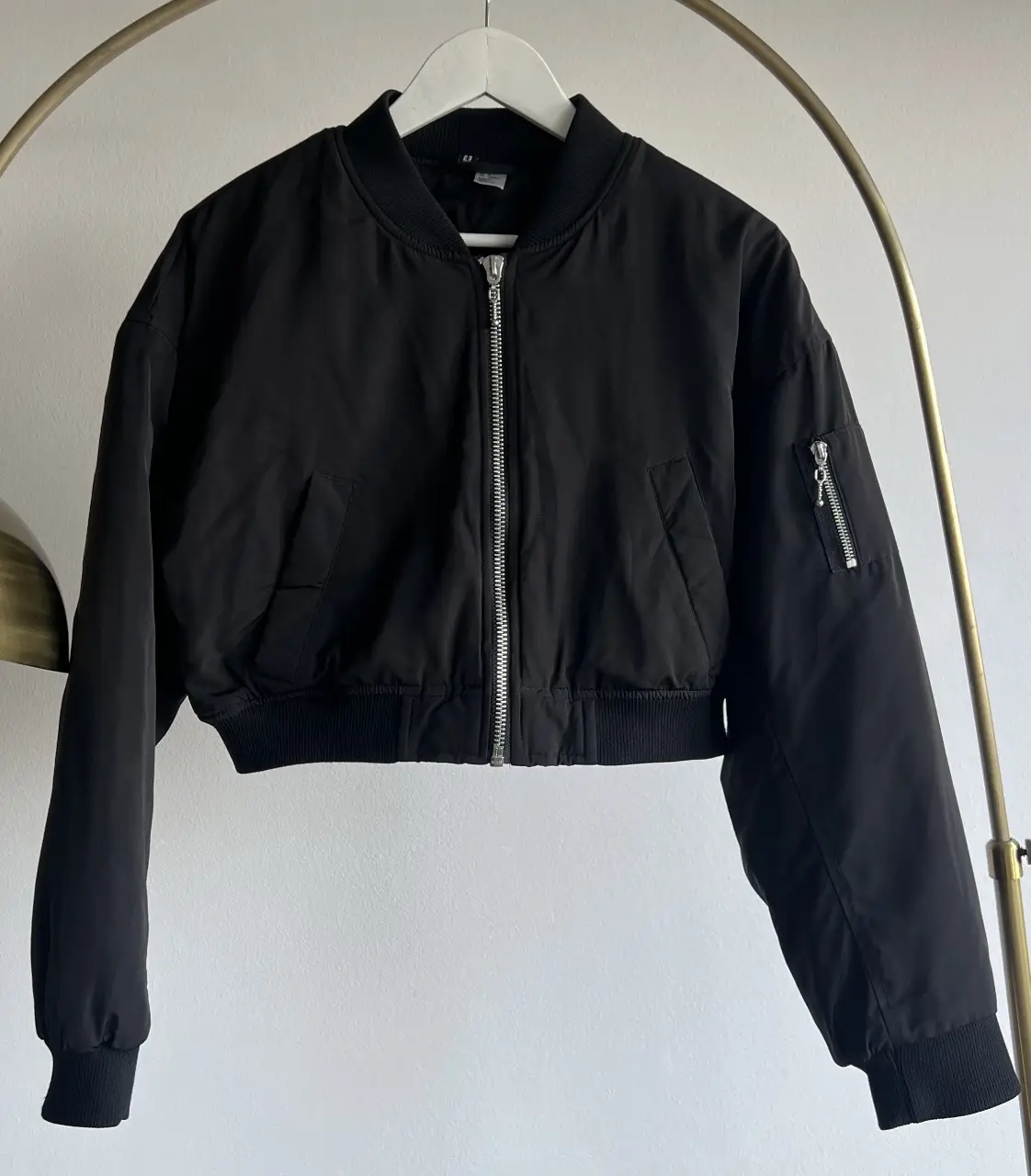 Campera bomber negra, ideal para un look casual y moderno. Confeccionada en un tejido resistente y con detalles como bolsillos y cierre frontal. Perfecta para usar en cualquier ocasión.
