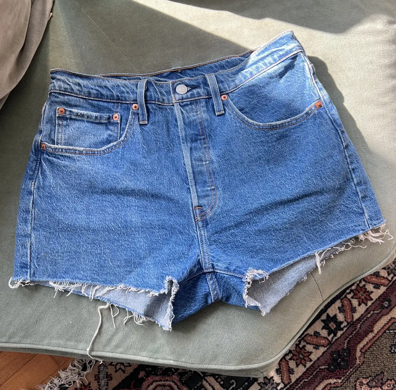 Short de jean de mujer Levi’s , tiro medio , con corte desflecado en el bajo. Ideal para el verano.