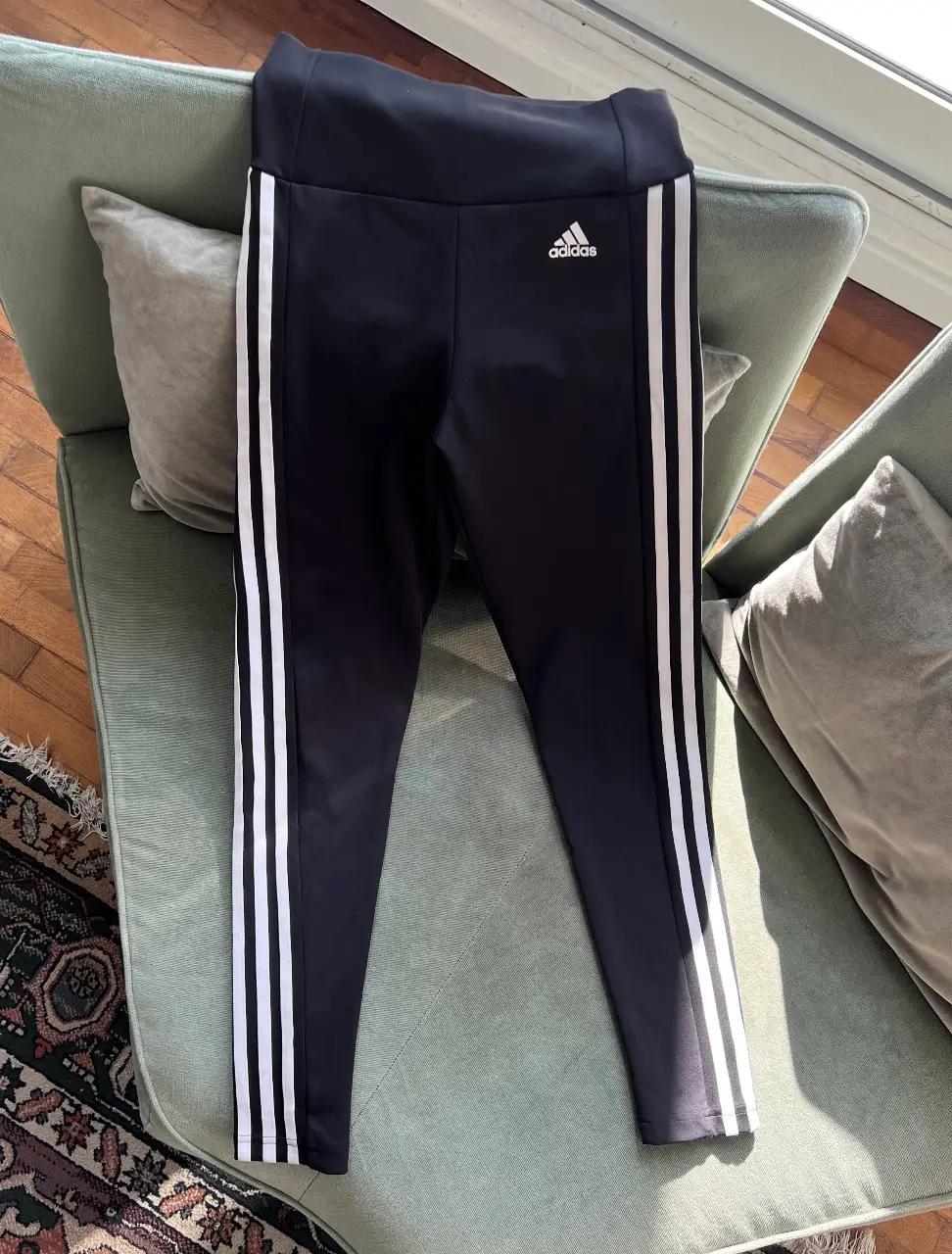 Calzas deportivas Adidas negras con las tres tiras blancas a los costados. Talle XS. Con tecnología Aeroready.