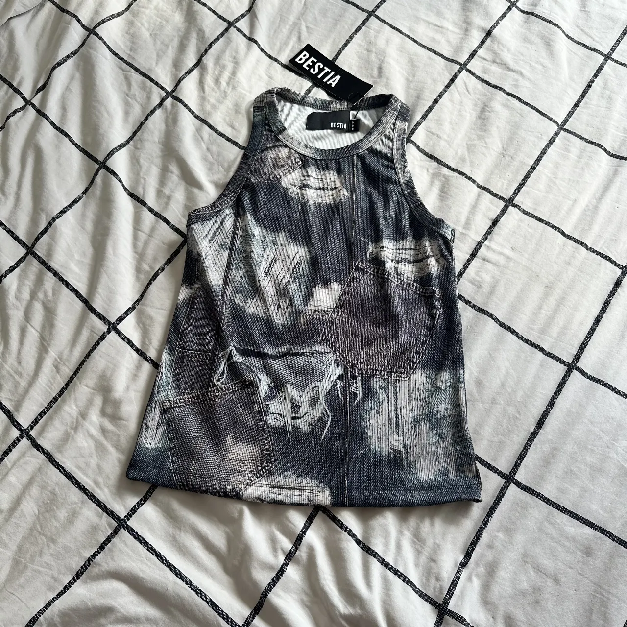 Musculosa estampada estilo "denim" con detalles desgastados y bolsillos falsos. Ideal para un look urbano y canchero. Es bien elastizada y va al cuerpo. Nuevo con etiqueta. 