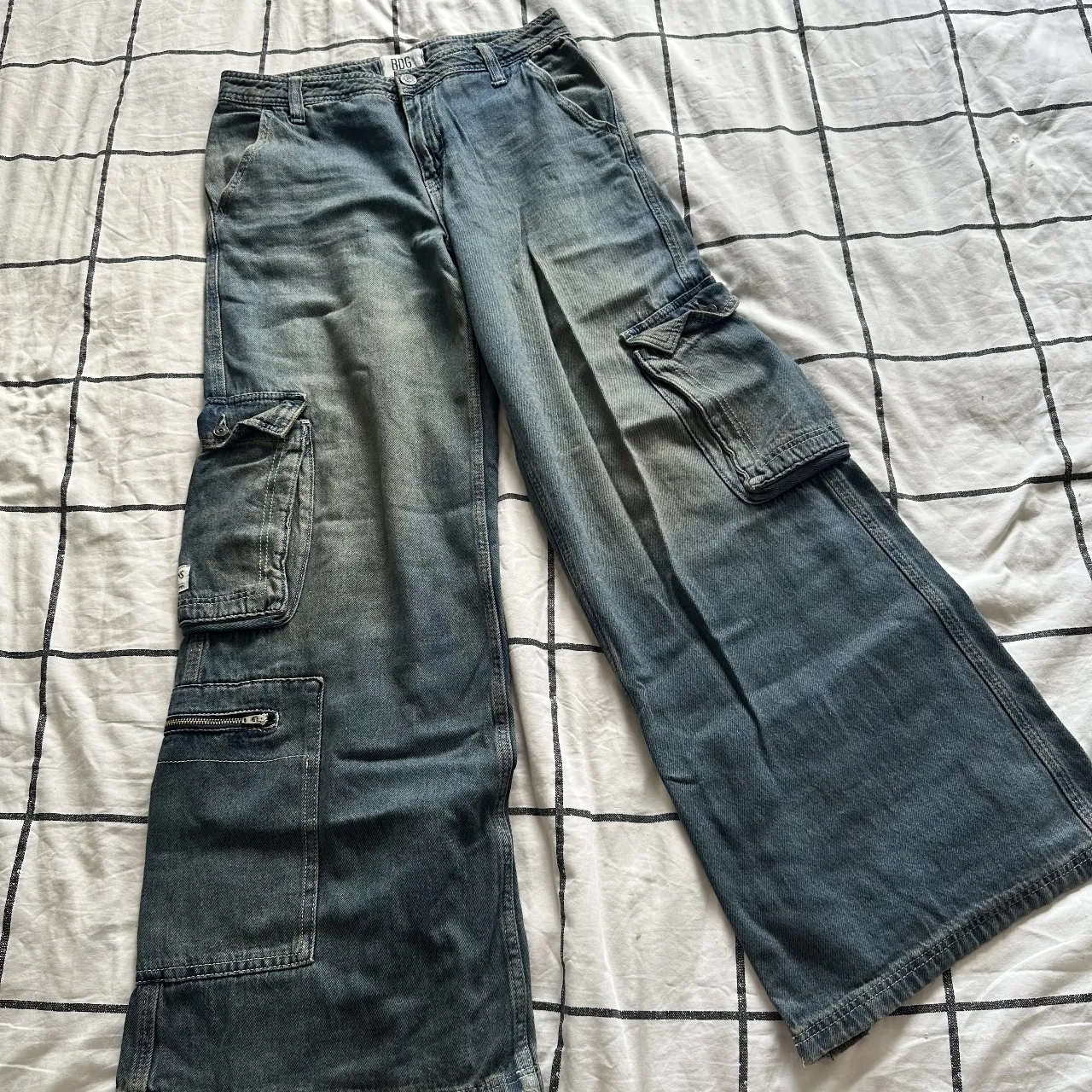 Jean cargo tiro medio, corte ancho y desgastado. Tiene un detalle en la botamanga porque me quedaba largo pero lo debo haber usado dos veces.