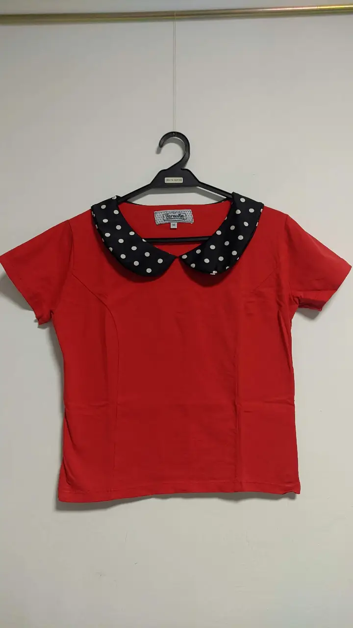 Remera roja de mujer con cuello Peter Pan en negro con lunares blancos. Ideal para un look retro y femenino.