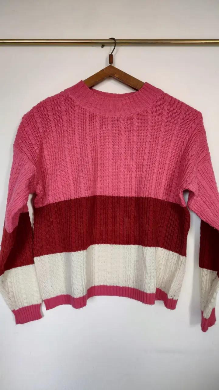 Sweater de mujer a rayas horizontales en tonos rosa, rojo y blanco. Cuello alto (no es polera) y mangas largas. Ideal para un look casual y abrigado. Talle único, equivale a S/M 