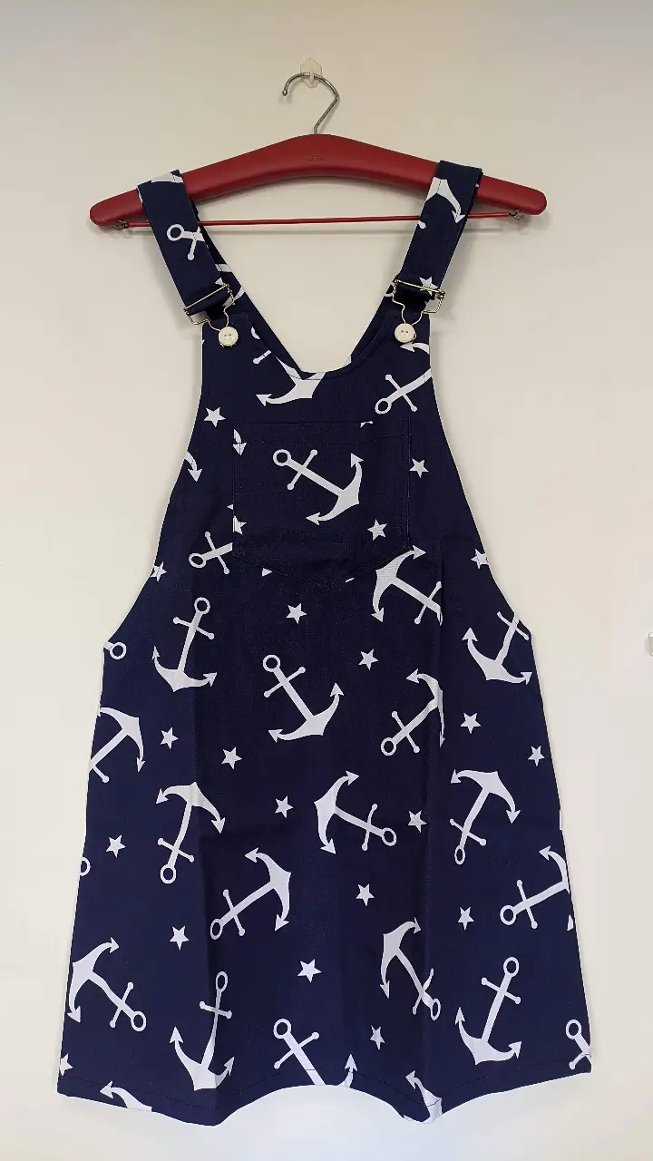 ¡Divertido y fresco! Jumper corto de gabardina azul marino con estampado de anclas blancas y estrellas. Breteles regulables. Perfecto para un look casual.