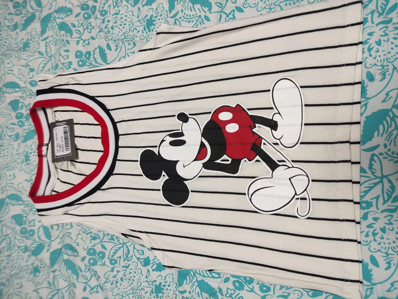 Musculosa con diseño de Mickey Mouse. Rayas horizontales blancas y negras, cuello y bordes rojos. Ideal para un look casual y divertido.