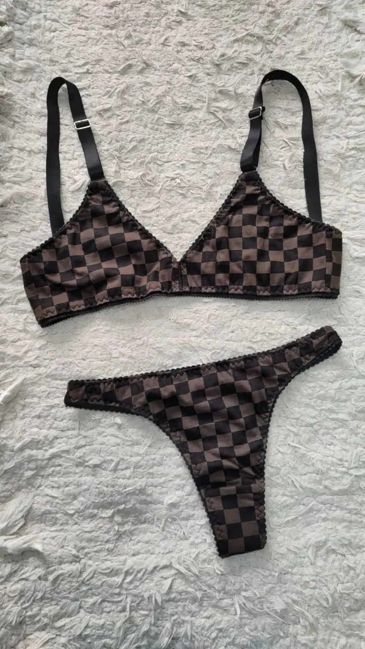 Conjunto de lencería con estampado a cuadros en tonos marrones y negros, de algodon. Incluye corpiño triangular y bombacha colaless, ambos con detalles de puntilla. Talle 100, pero chico, ideal 95 de busto. Nuevo, sin uso, en su caja.