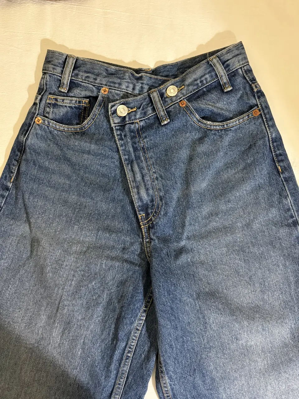 Jeans de mujer con diseño cruzado en la cintura, tiro alto, talle 34 EUR, 2 USA. Un jean moderno y canchero, ideal para armar looks casuales con onda.