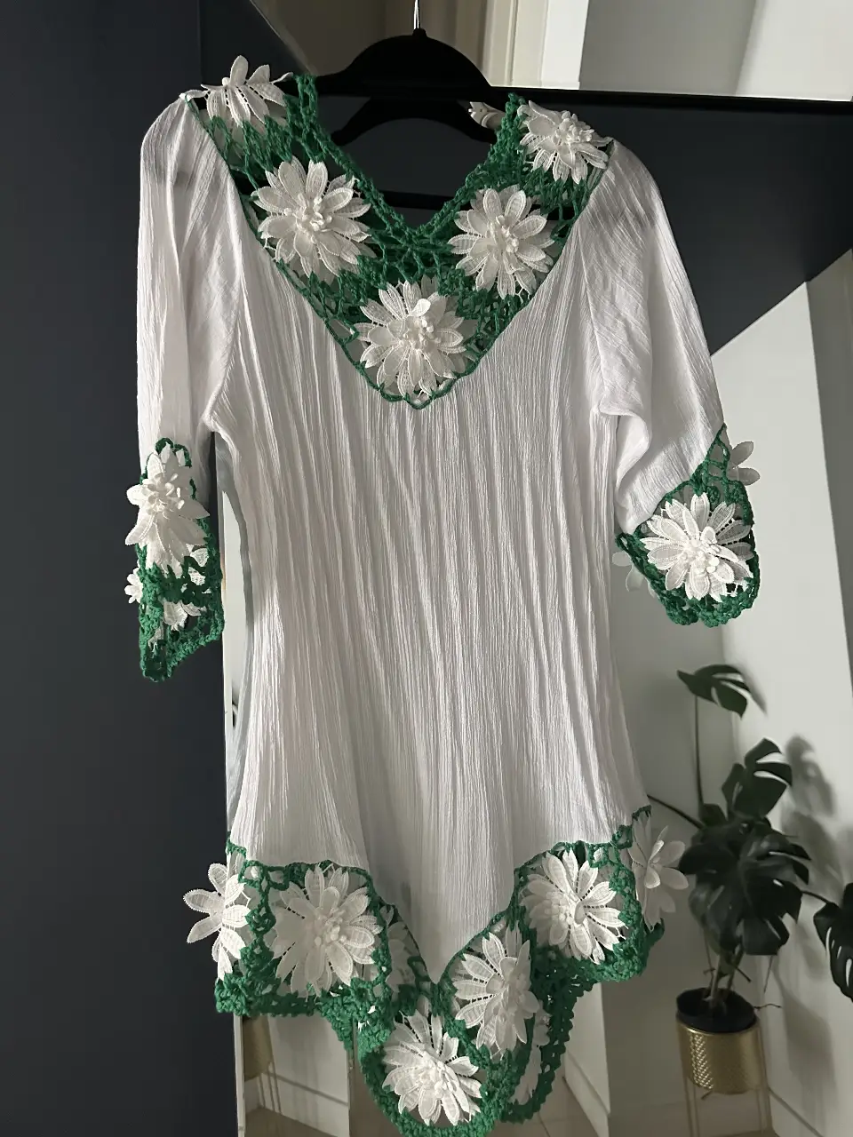 Vestido mini blanco con detalles florales en verde y blanco. Ideal para un look fresco y artesanal.