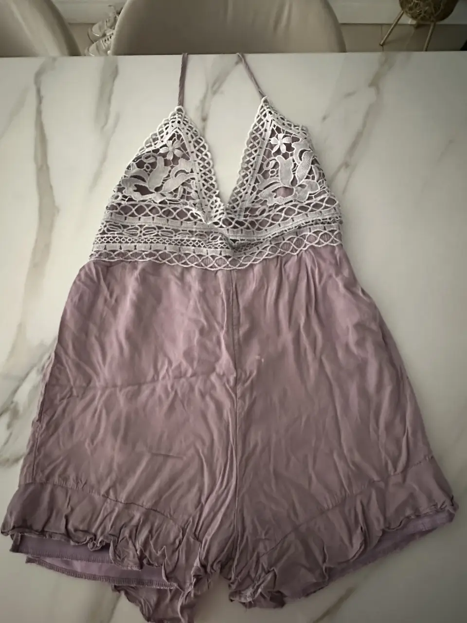 Mono corto de mujer, color lila con detalles de encaje blanco en la parte superior. Ideal para un look casual y fresco.
