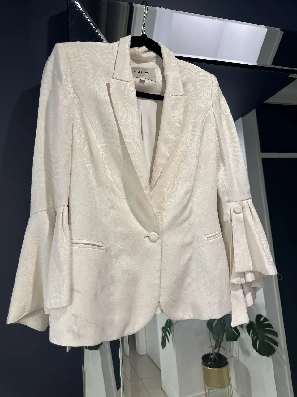 Elegante blazer de mujer en color crudo, con un diseño sofisticado y detalles únicos. Cuenta con mangas acampanadas que le dan un toque de originalidad y estilo. Perfecto para ocasiones formales o para darle un toque chic a tu look diario.