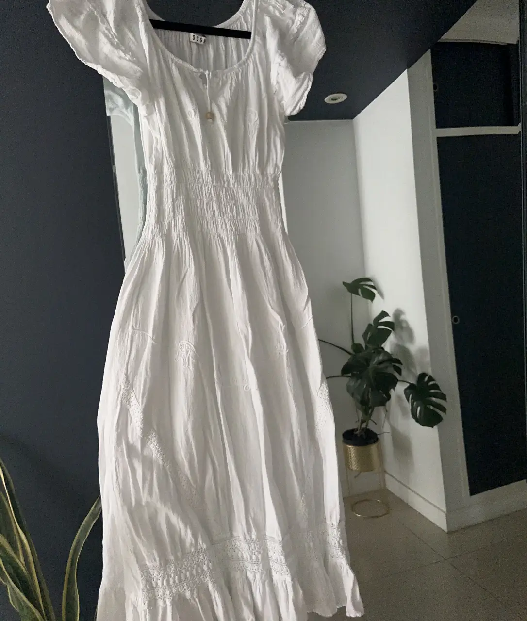 Vestido largo blanco, estilo boho, con detalles de encaje y ajuste en la cintura. Ideal para un look fresco y relajado.