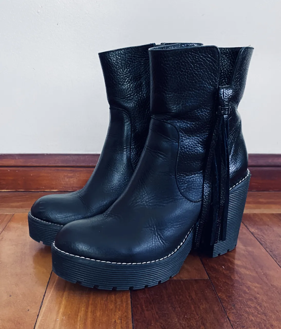 GUSTAVO CASSIN. Botas de cuero negras,  con plataforma y taco; flecos de cuero laterales y pespuntes blancos. 
Excelente estado; un solo uso. 
Se entrega con caja y embalaje originales. 