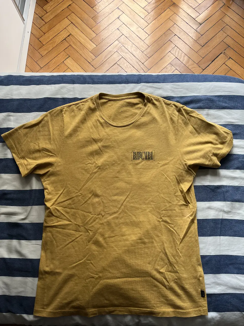 Remera Rip Curl amarilla con logo estampado en el pecho y en la espalda. Talle XL, ideal para un look casual y relajado.