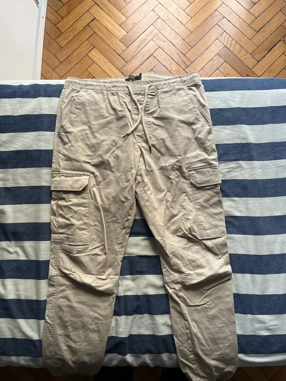 Pantalón cargo color khaki de hombre, con bolsillos laterales y ajuste en la cintura. Ideal para un look casual y cómodo.