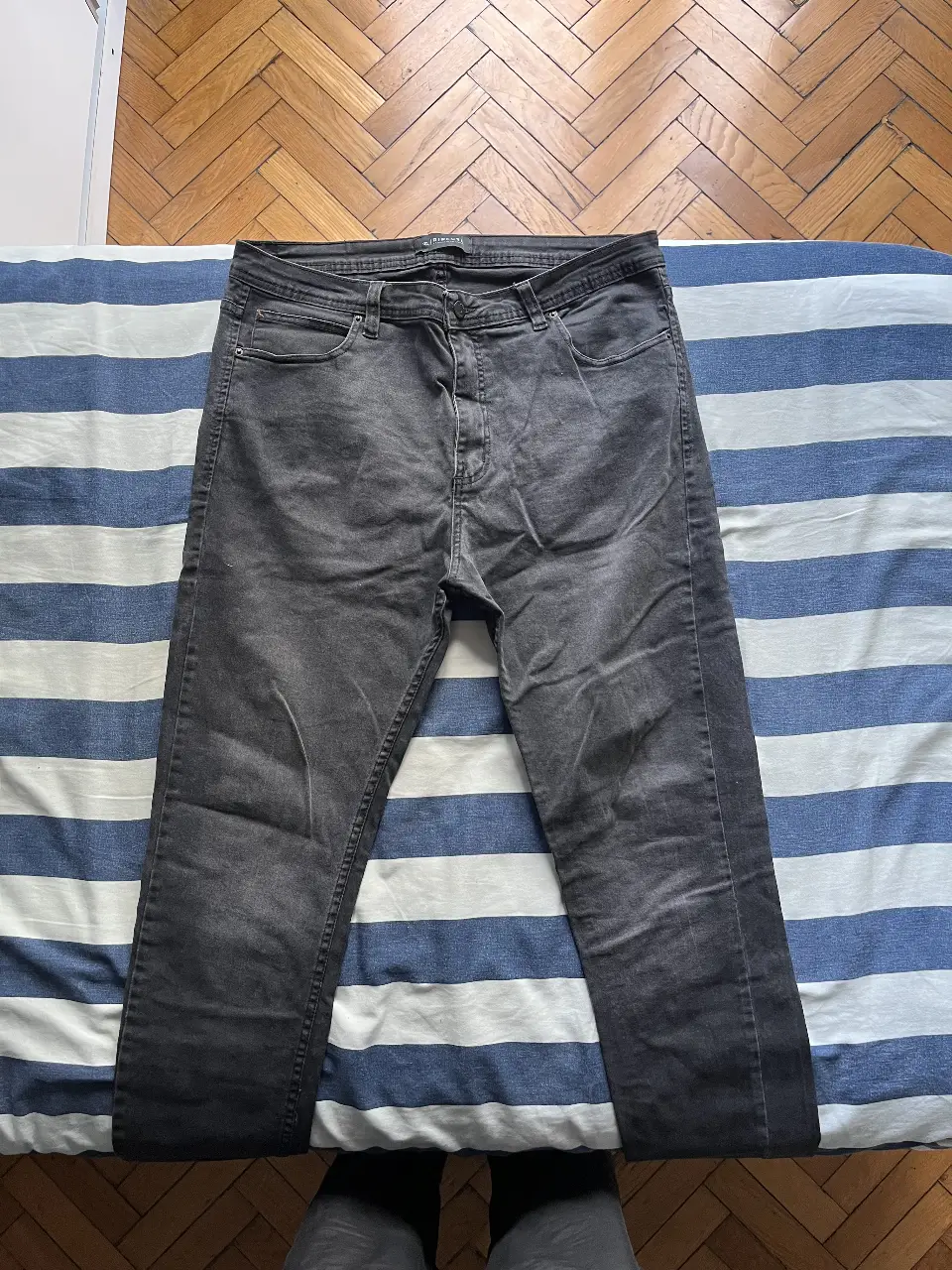 Jeans rectos de hombre, color gris oscuro, de la marca Rip Curl. Un clásico para cualquier ocasión. Es ajustado.