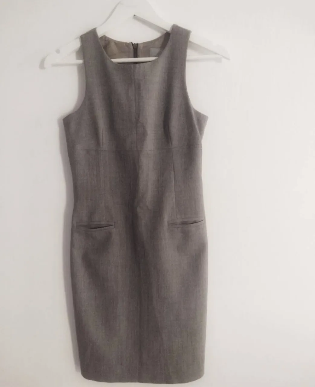 Vestido gris de tela, sin mangas y con bolsillos. Ideal para un look formal o de trabajo.