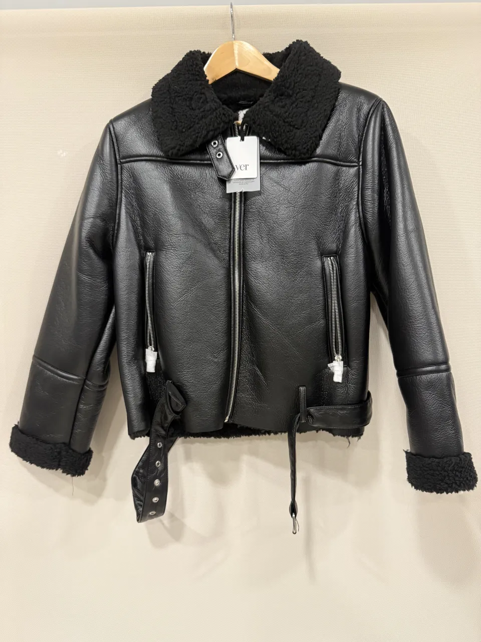 Campera de cuero sintético negra, estilo aviador, con cuello y puños de corderito. Tiene cierre al frente, bolsillos con cierre y cinturón en la cintura. Ideal para un look canchero y abrigado.