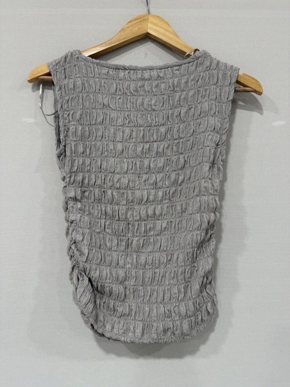 Top gris con textura fruncida y detalles drapeados. Diseño moderno y versátil, ideal para looks casuales y cancheros.