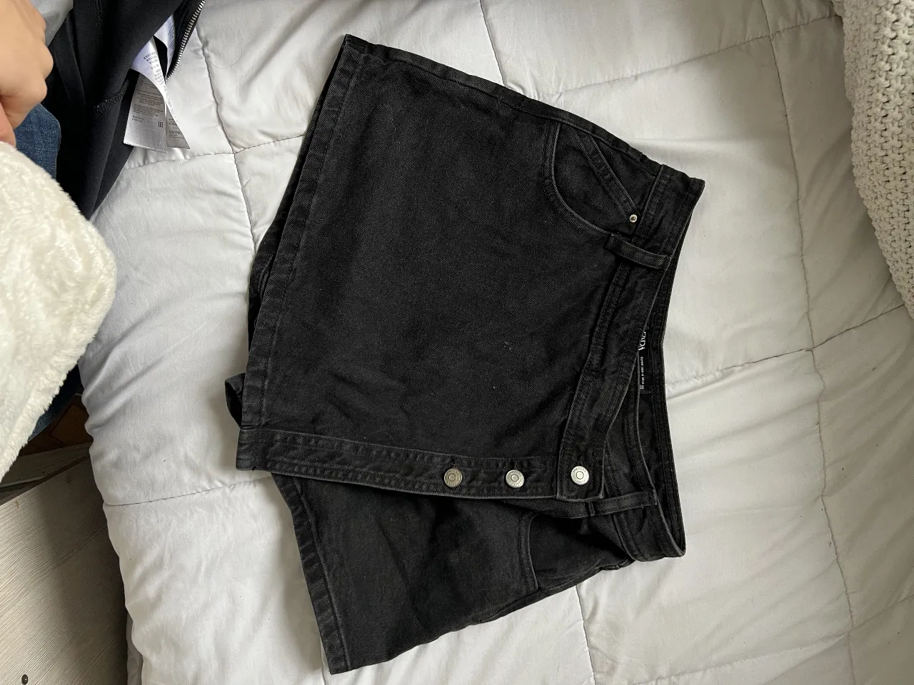 Short de jean negro de mujer, con botones y bolsillos. Ideal para un look casual y moderno.