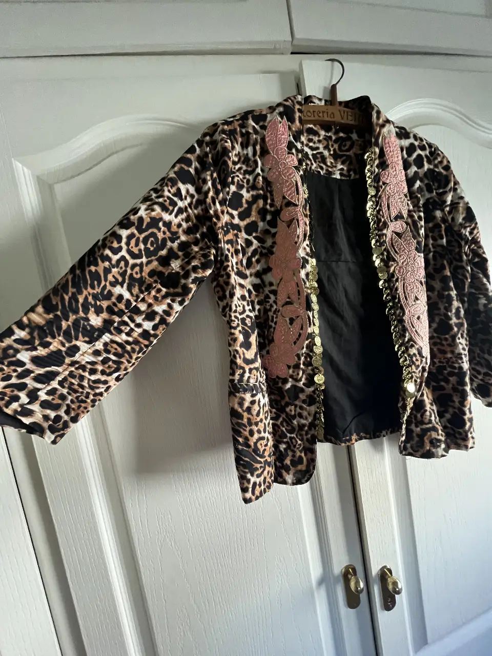 Chaqueta blazer con estampado animal print, detalles en rosa y dorado. Ideal para un look de fiesta o salida.