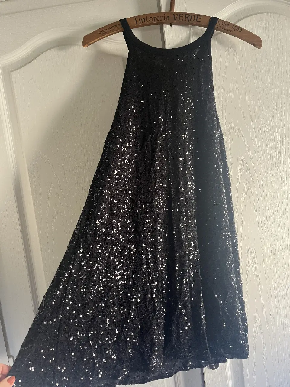 Vestido mini negro con lentejuelas, ideal para fiestas y eventos especiales. Diseño halter que realza la figura, perfecto para lucir en la noche.