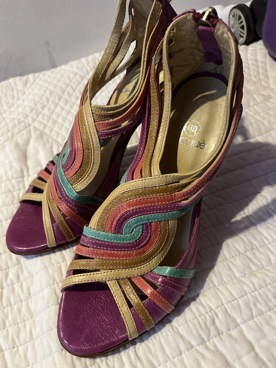Sandalias de taco alto con diseño multicolor y detalles en violeta. Ideales para darle un toque de color y estilo a tus looks de fiesta.
