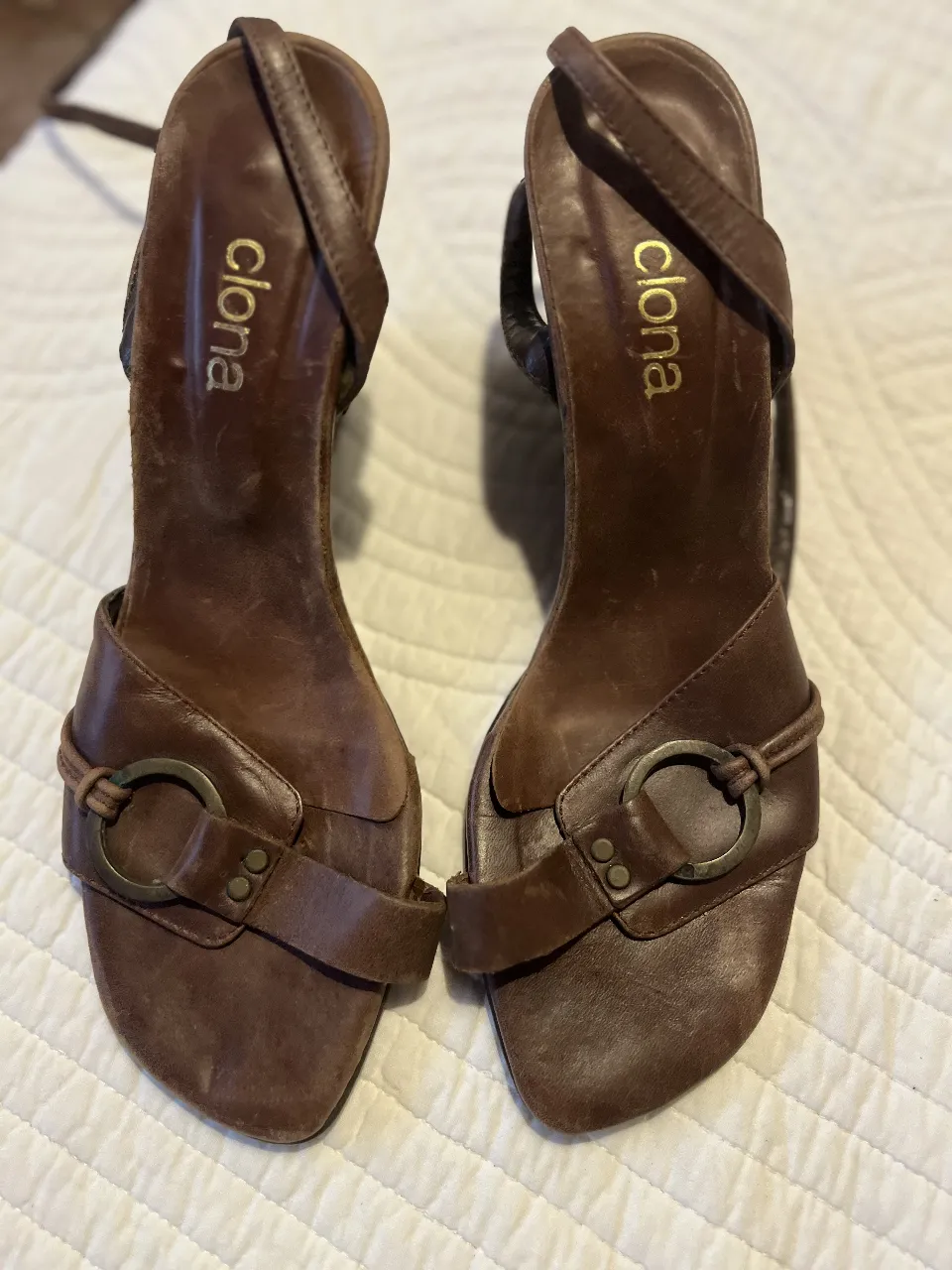 Sandalias de cuero marrón con detalles de hebilla y diseño elegante. Ideales para un look sofisticado.