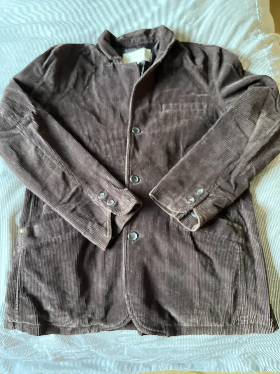 Chaqueta de hombre de corderoy marrón, con botones y bolsillos. Ideal para un look casual y elegante.