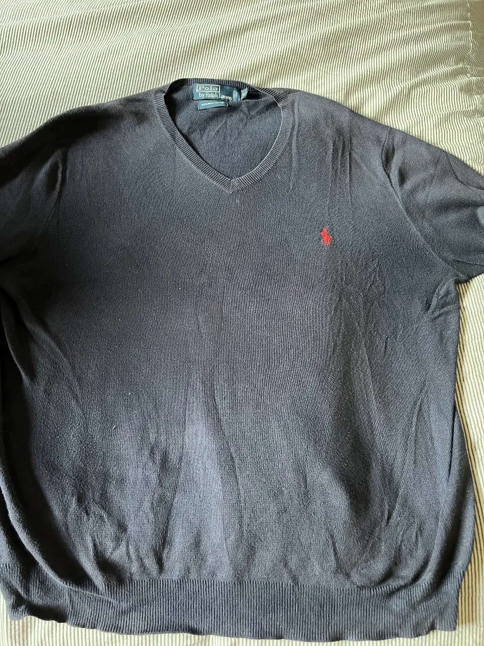 Sweater Polo by Ralph Lauren azul marino de hombre, con cuello en V y logo bordado en rojo. Ideal para un look casual y elegante.