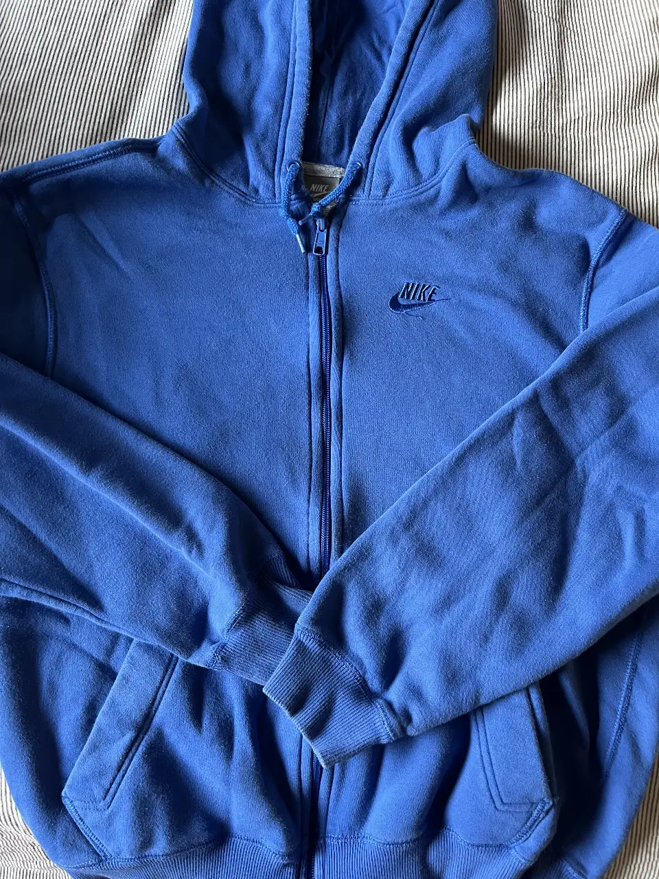Buzo con cierre Nike azul, ideal para un look deportivo y casual. Confeccionado en un tejido suave y cómodo, este buzo es perfecto para usar en cualquier ocasión.