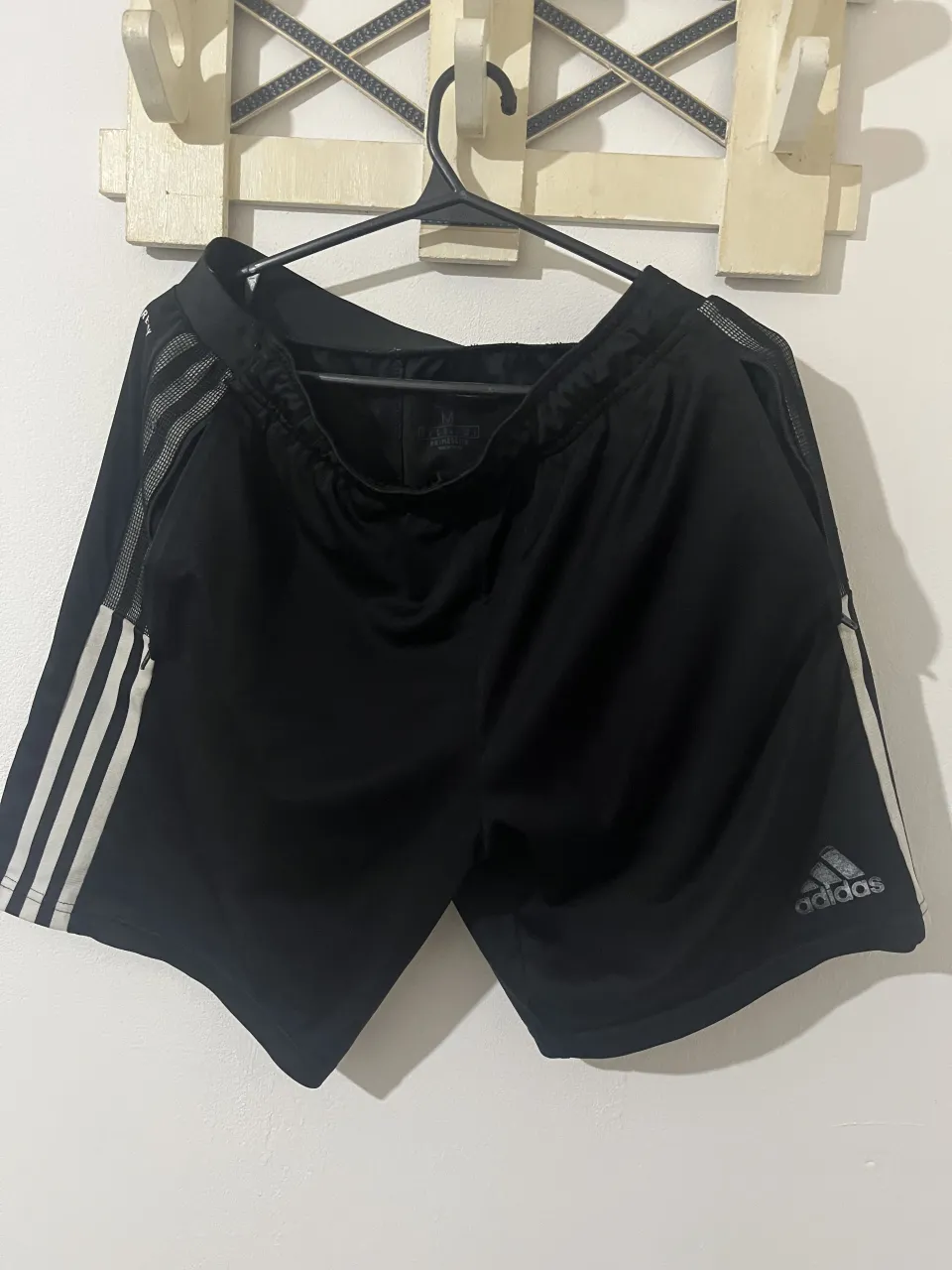 Shorts deportivos negros con tres tiras blancas a los costados y logo de Adidas gris. Poseen bolsillos con cierre.

dice M pero va para L también 