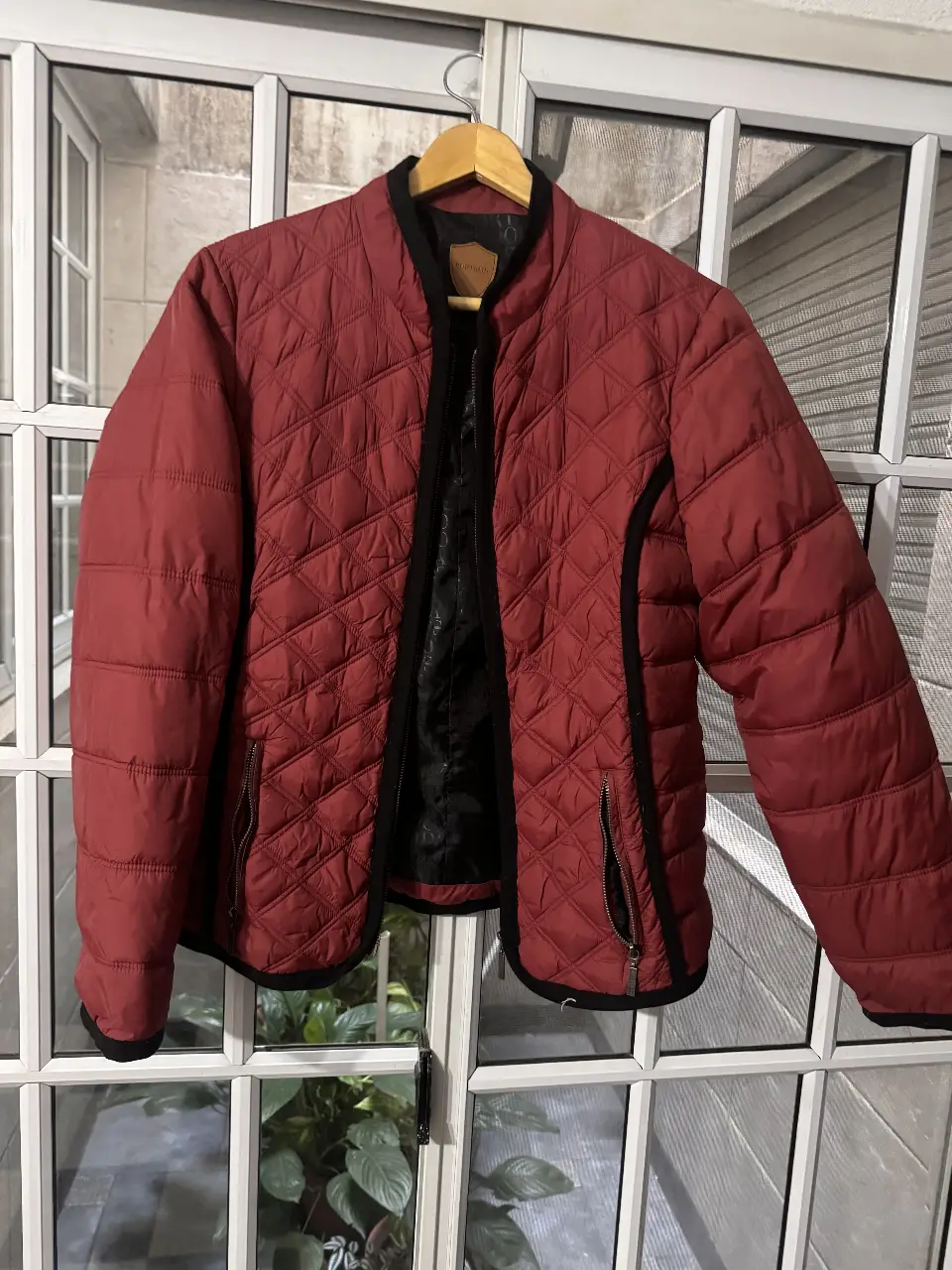 Campera acolchada roja con detalles en negro, ideal para el invierno. Posee cierre y bolsillos con cierre. Marca PortsAid.