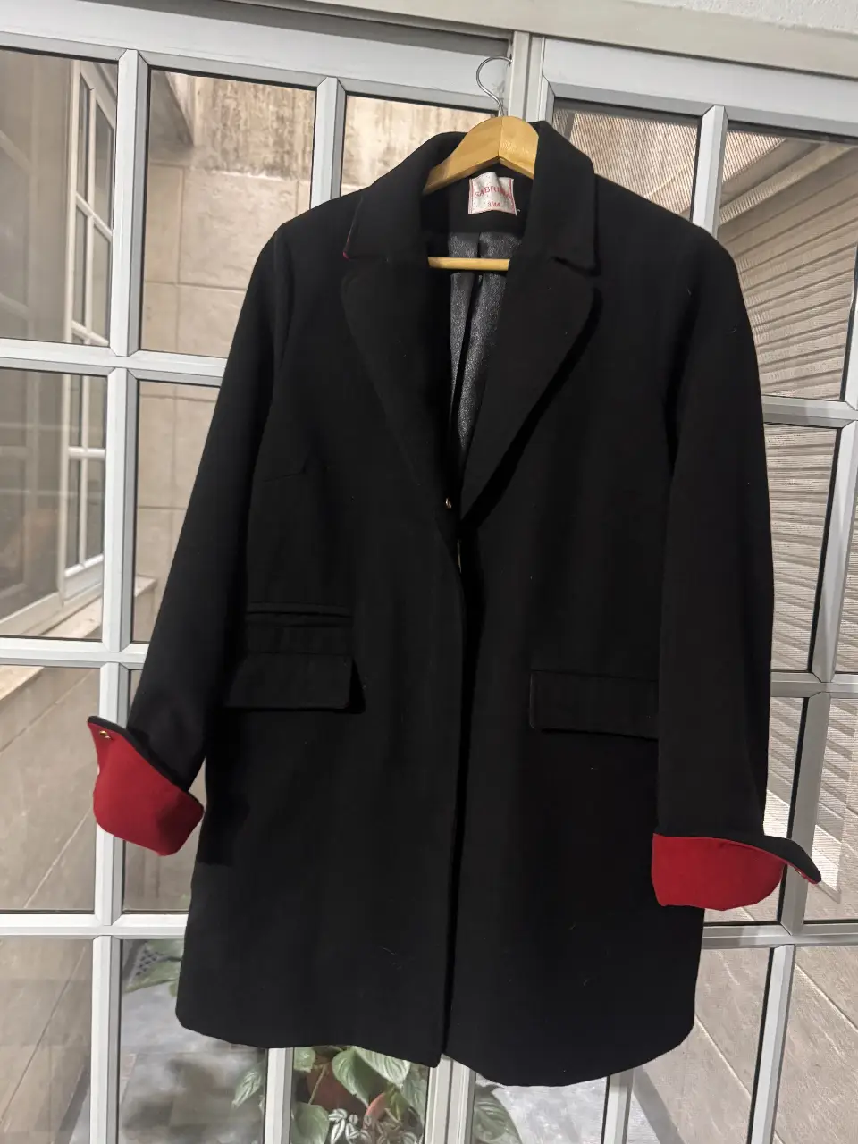 Tapado negro de paño con detalles en rojo en los puños. Ideal para un look elegante y abrigado en invierno. Marca Sabrina, talle 3/44.