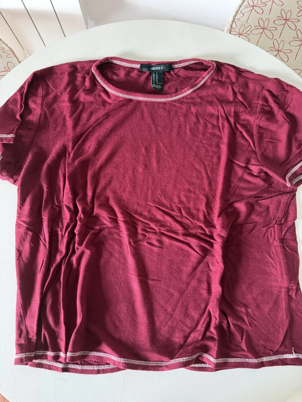 Remera de algodón color bordó con detalles de costura blanca en cuello y mangas. Ideal para un look casual y cómodo.