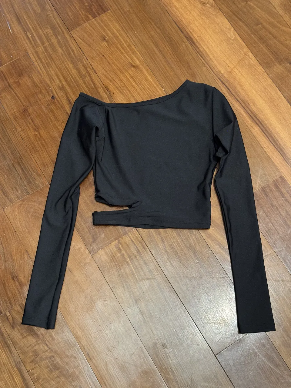 Top negro manga larga con recortes cut out. Diseño moderno y audaz, ideal para un look canchero y a la moda. Perfecto para salidas nocturnas o para darle un toque especial a tu outfit.