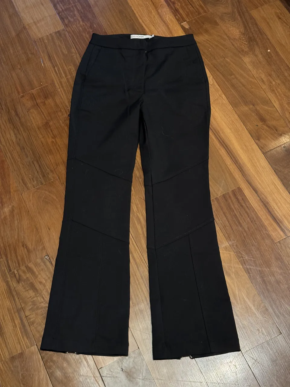Pantalón negro tiro alto con cortes geométricos y cierres en los tobillos. Diseño moderno y canchero, ideal para looks urbanos y con un toque rockero.