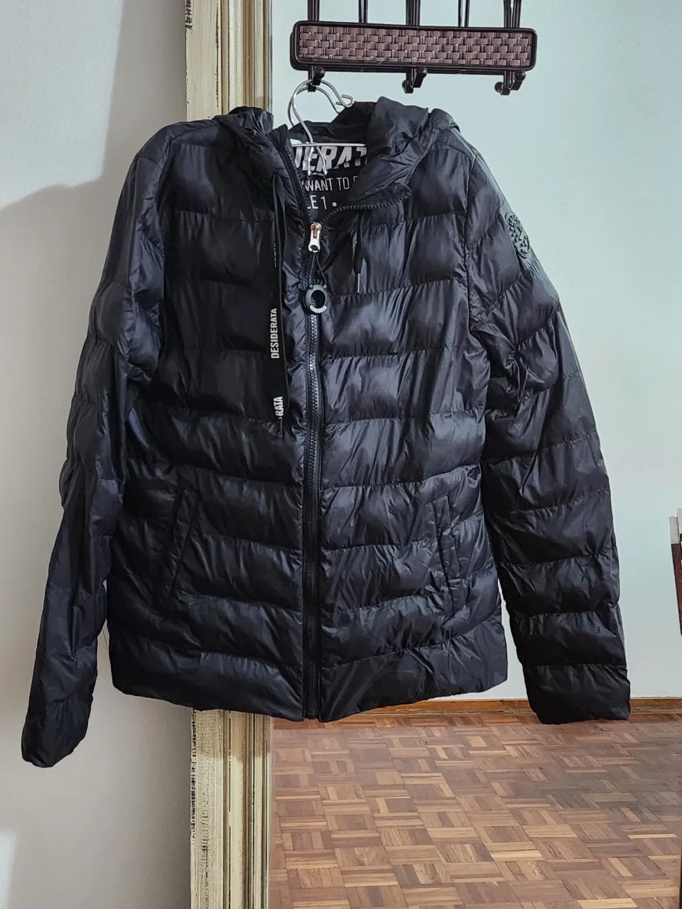 Campera de plumas negra con capucha, ideal para el frío. Perfecta para un look casual y abrigado.