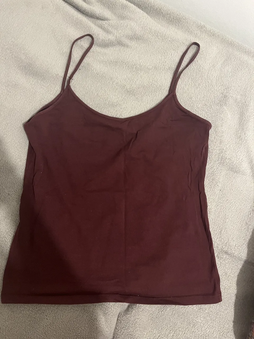 Top de mujer color borgoña con tirantes finos. Ideal para combinar con jeans o faldas. 