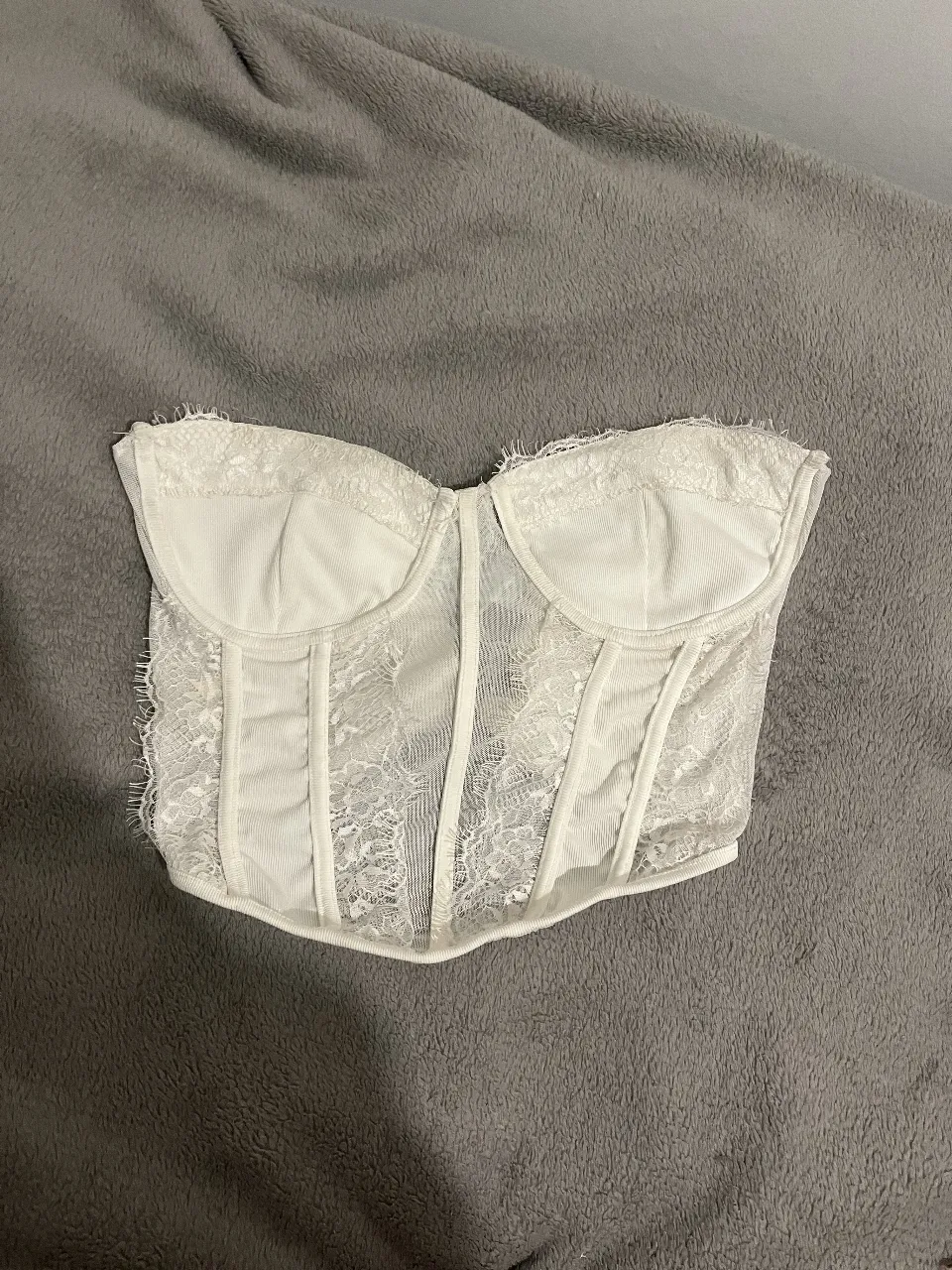 Top corset blanco con detalles de encaje. Ideal para looks de fiesta o salidas.