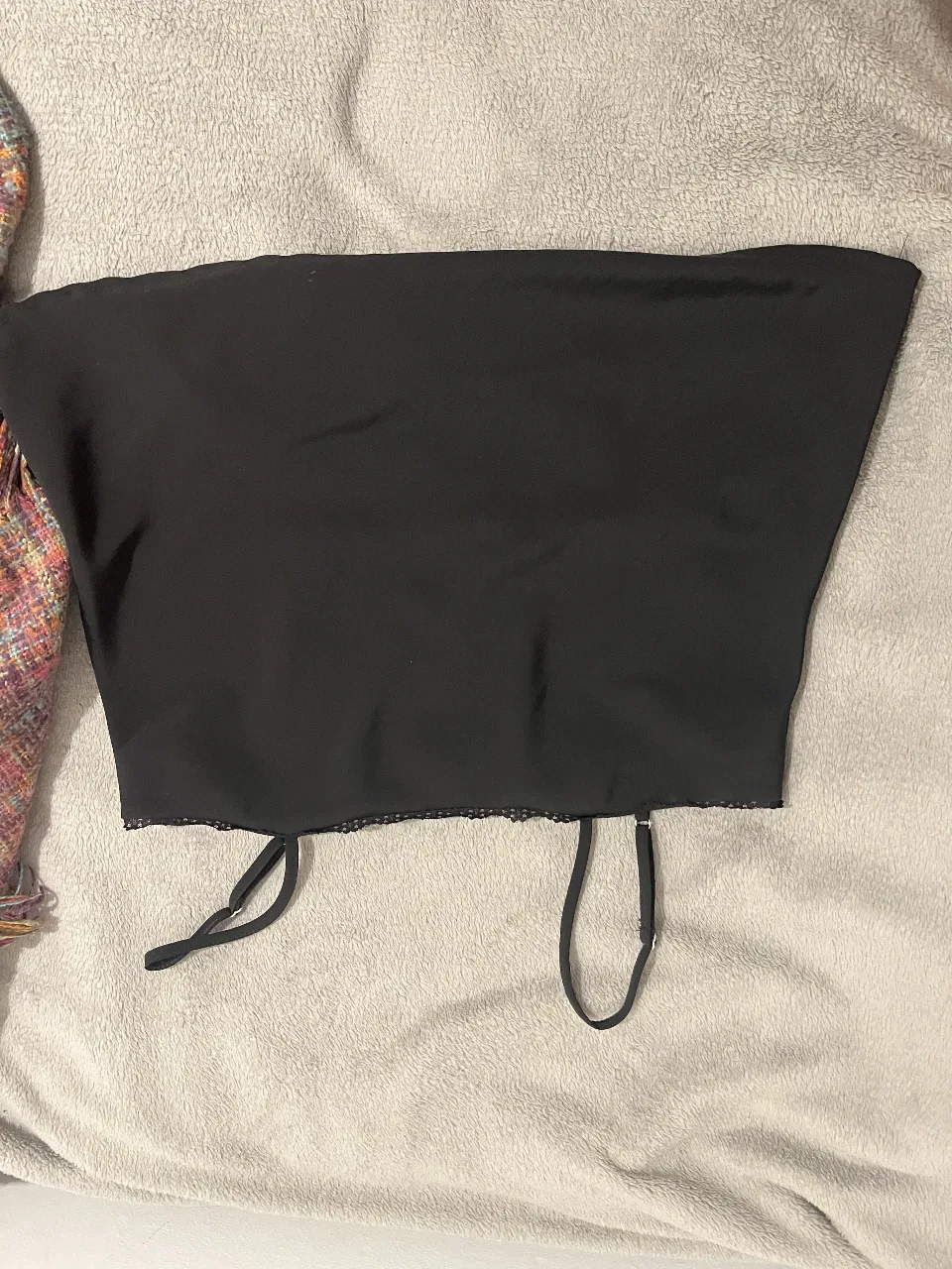 Top negro con tirantes finos y detalle de encaje en la parte superior. Ideal para combinar con diferentes outfits. 1 solo uso
