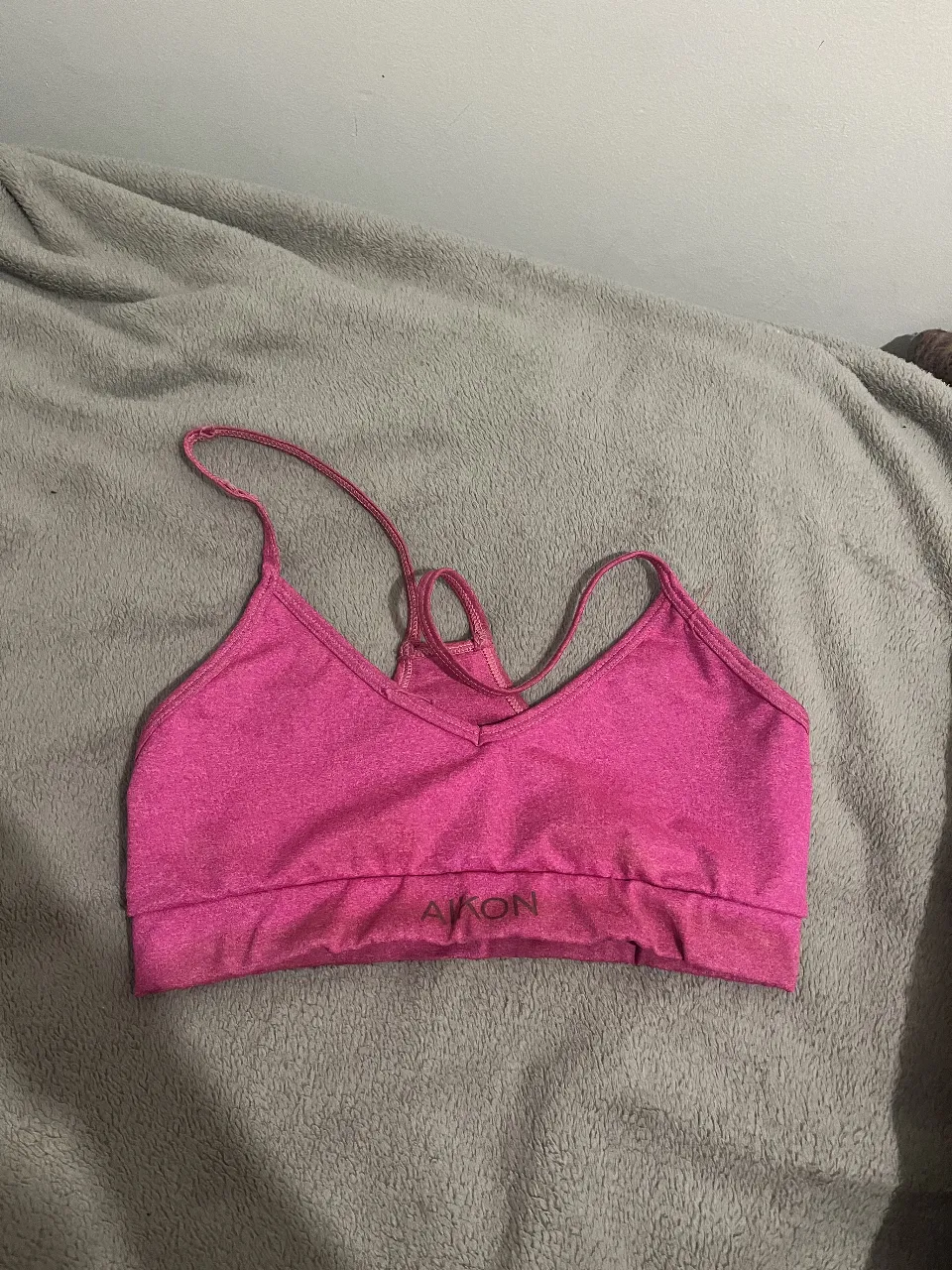 Top deportivo rosa con logo de la marca. Ideal para actividades de bajo impacto.