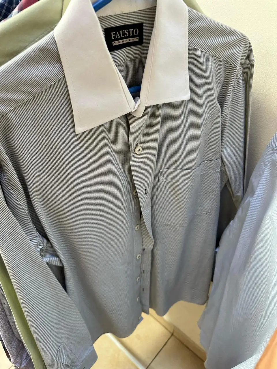 Camisa a rayas gris con cuello blanco, manga larga, estilo formal, ideal para el trabajo.
