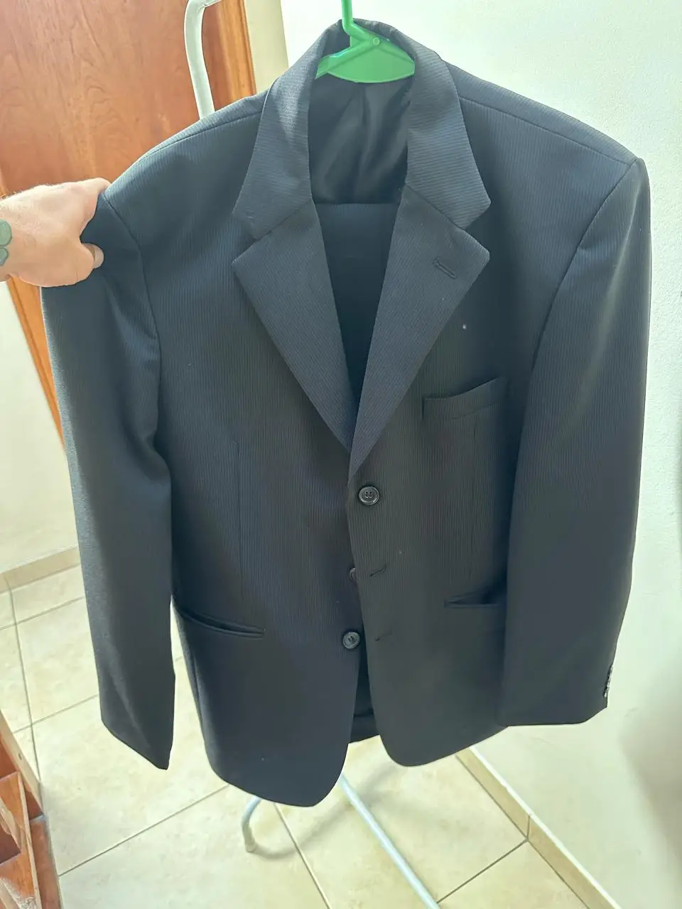 Traje de hombre negro, ideal para eventos formales y de trabajo. Incluye saco con dos botones y pantalón a juego, confeccionado en un tejido elegante y versátil.