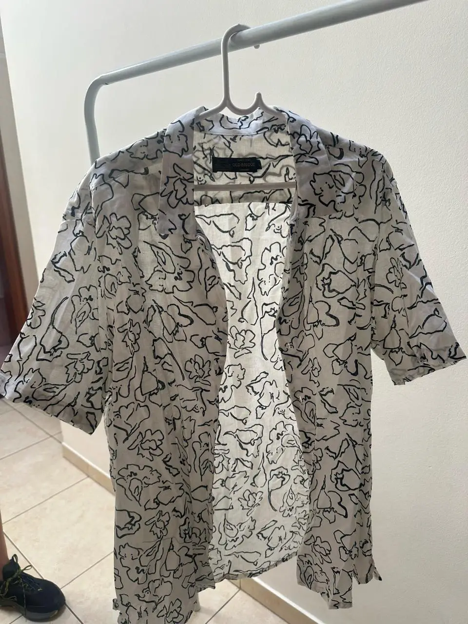 Camisa estampada con diseño floral en blanco y negro. Ideal para un look casual y fresco.
