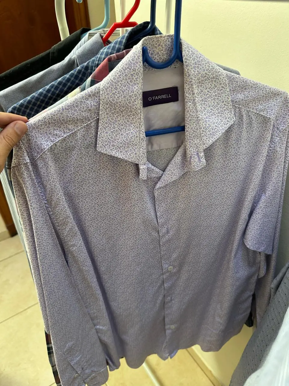 Camisa estampada para hombre, de manga larga, con cuello clásico y un patrón de diseño floral en tonos violetas.