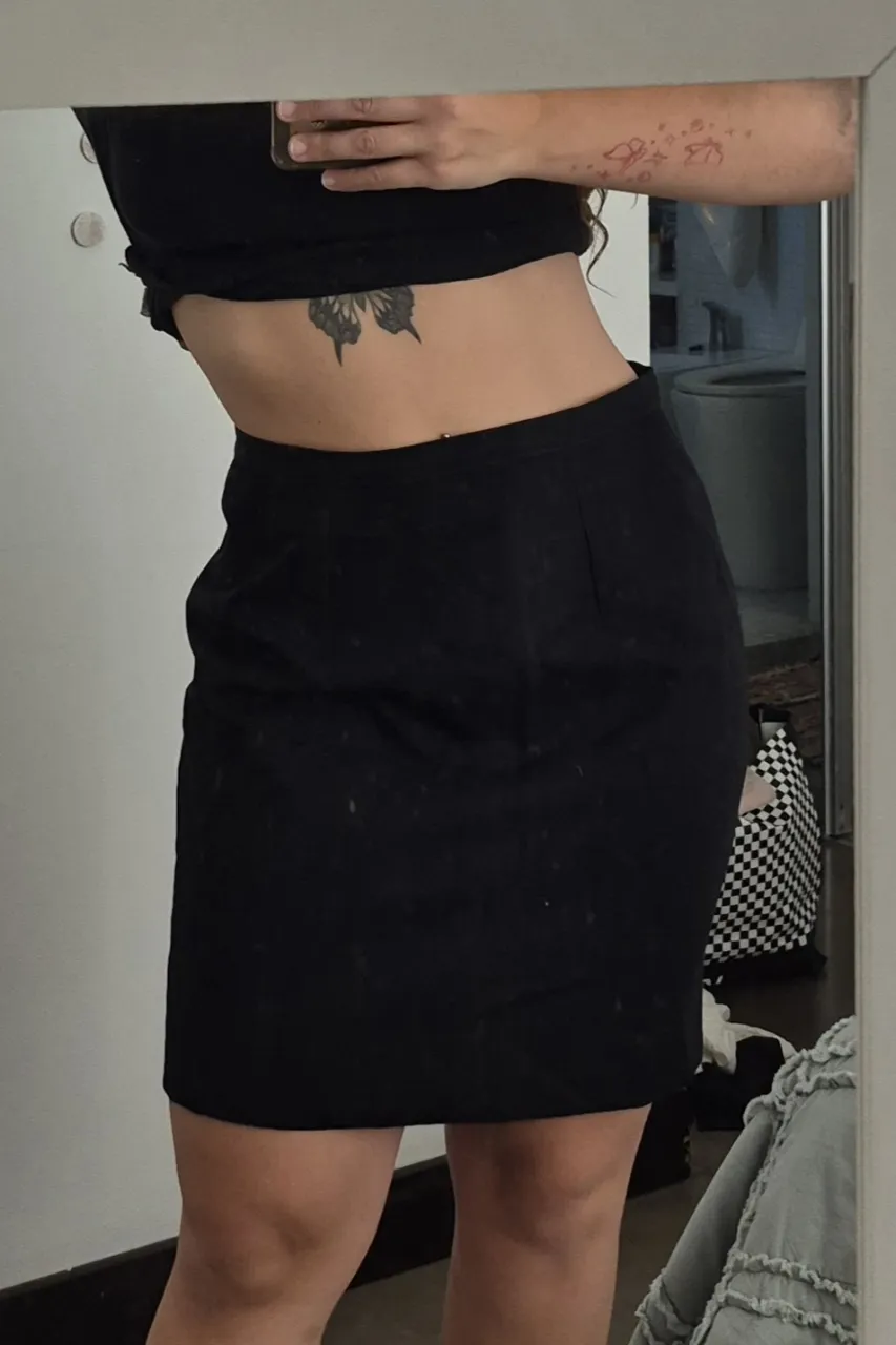 Pollera tubo negra corta, con cierre y botón. Falta una parte del "botón"