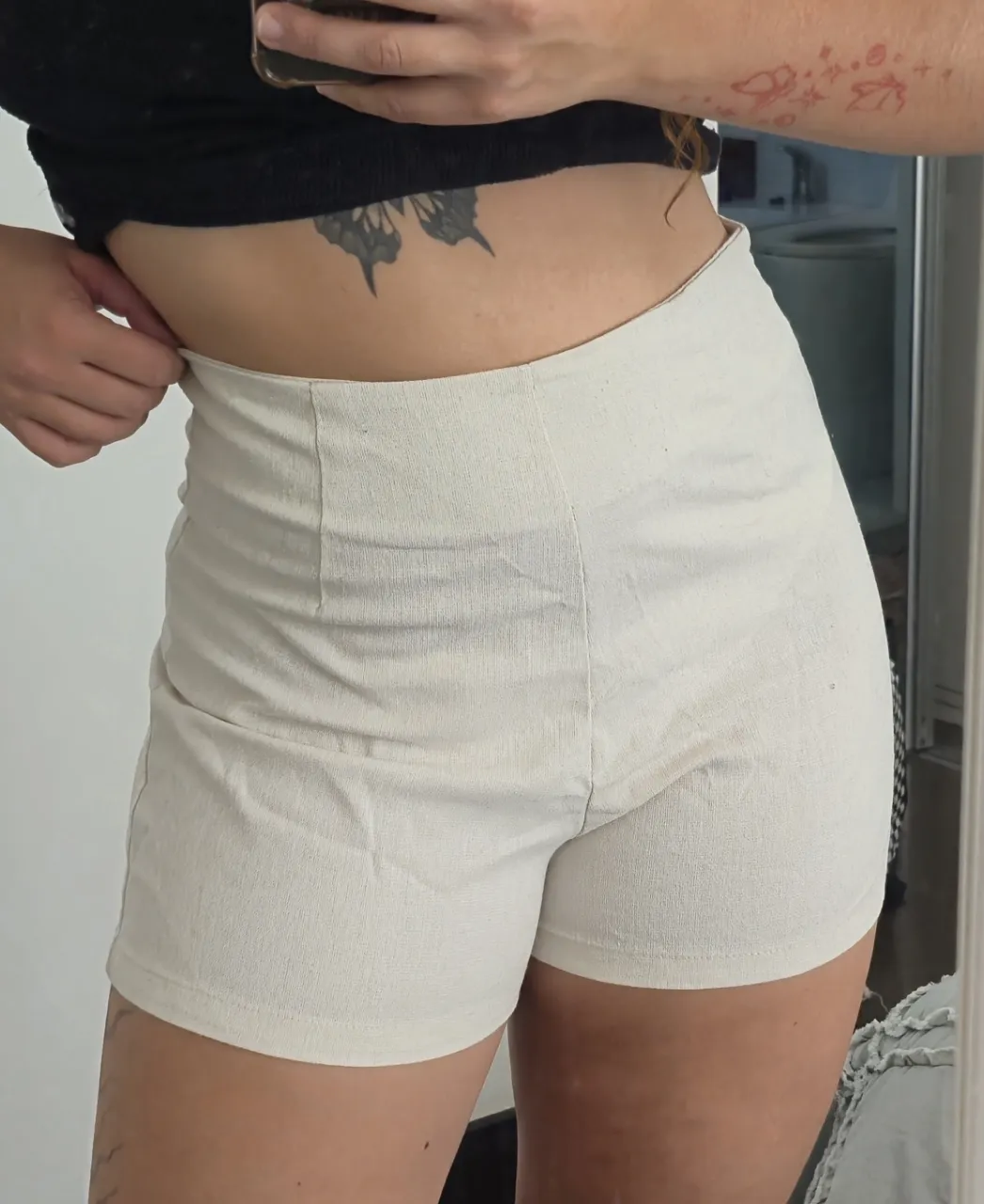 Shorts color crudo. Tiro alto con pinzas delanteras y cierre invisible en la espalda.