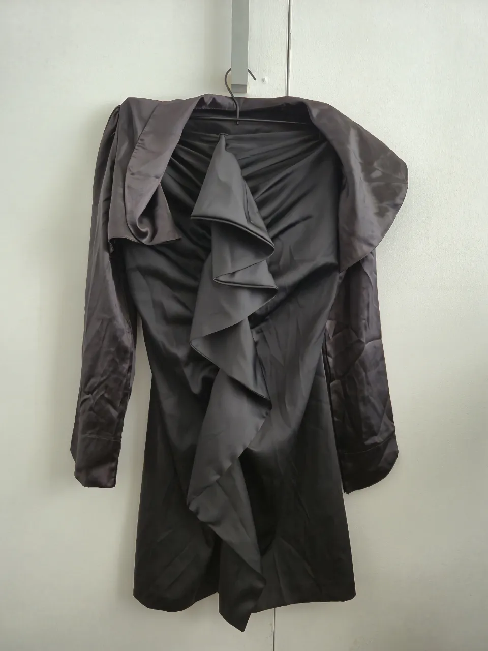 Vestido negro de satén con volados frontales y manguitas a juego.