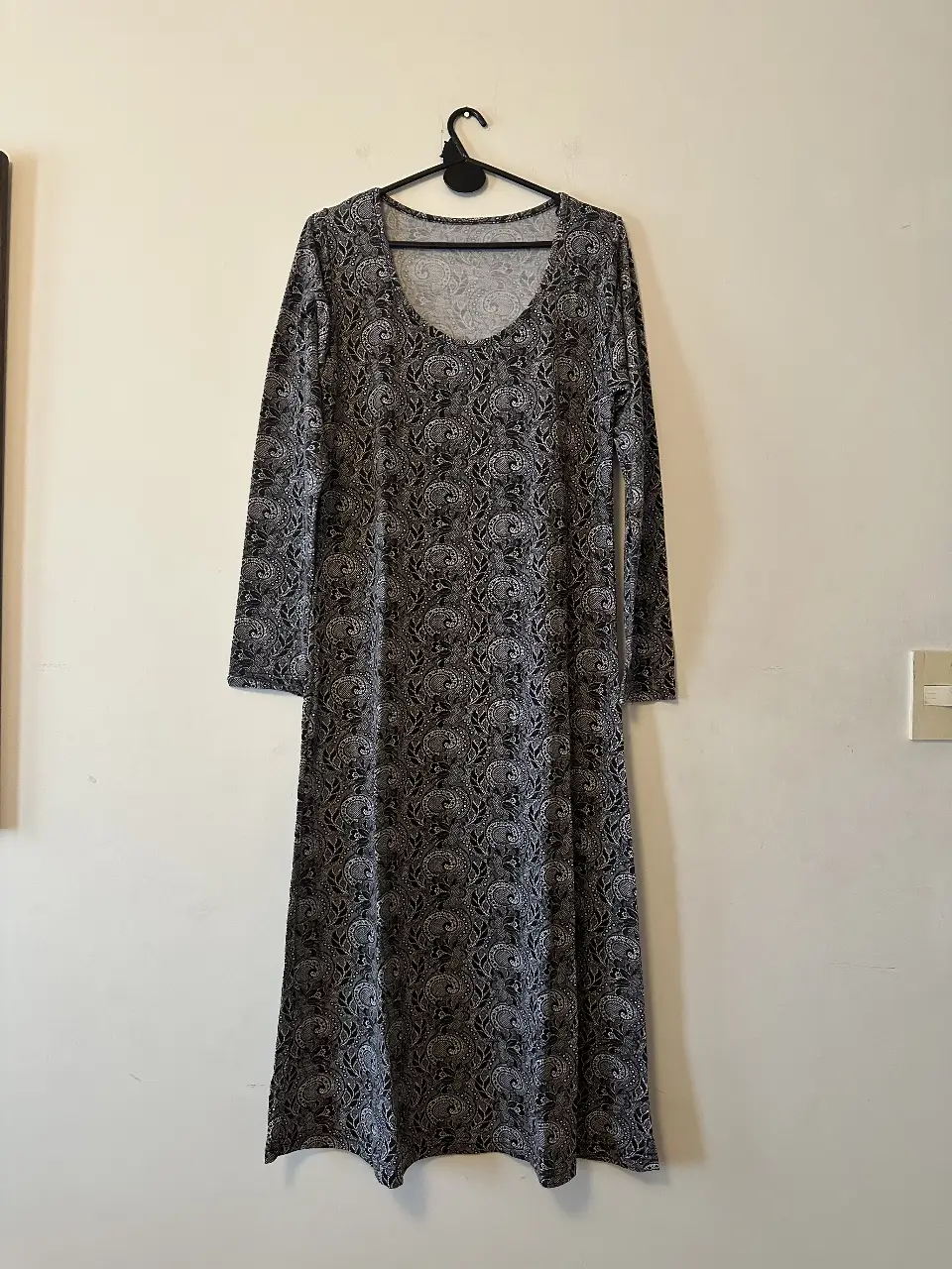 Vestido largo de mujer con estampado floral en tonos grises y blancos. Manga larga y cuello redondo. Ideal para un look casual y cómodo. Sin marca. 