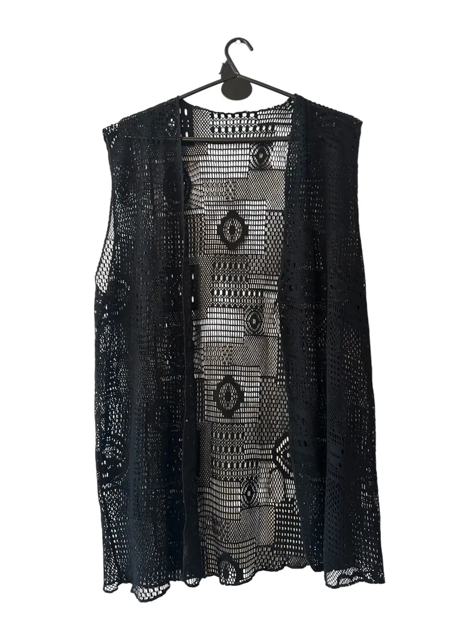 Chaleco negro de encaje, ideal para usar sobre otras prendas. Perfecto para un look bohemio o para darle un toque especial a cualquier outfit.
